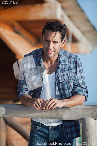 Image of Portrait of a man leaning against a railing