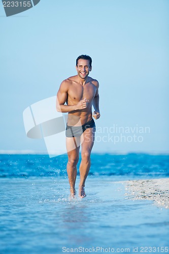 Image of Man running in water on the beach