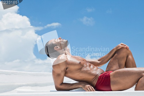 Image of Man sunbathing on the beach