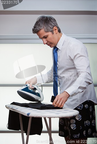 Image of Businessman ironing pants