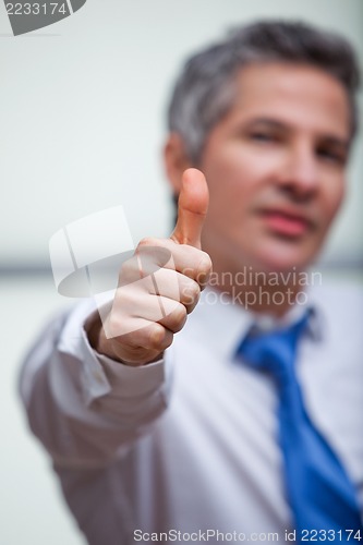 Image of Businessman gesturing thumbs up sign