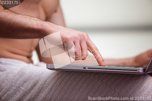 Image of Mid section view of a man using a laptop