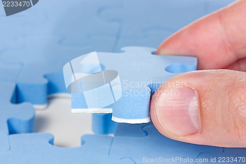 Image of Hand fitting the last puzzle piece