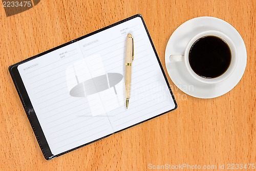 Image of Notebook and coffee cup on the table