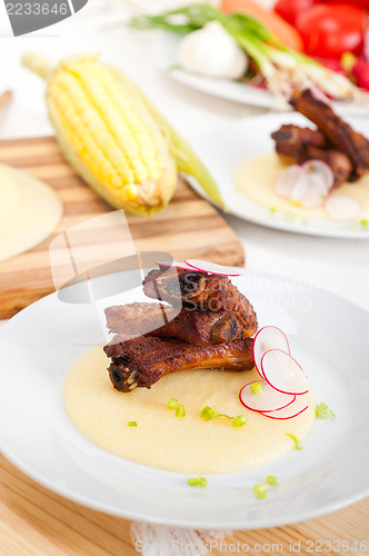 Image of pork ribs on polenta corn cream bed