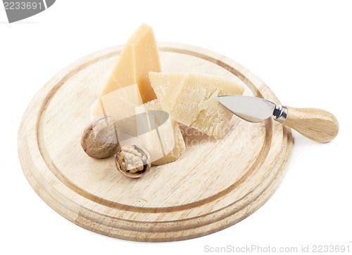 Image of Nuts and cheese on wooden board.