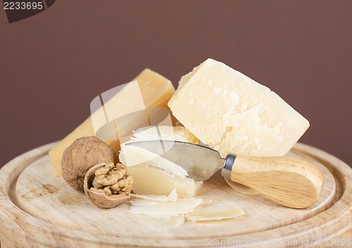 Image of Nuts and cheese on wooden board.