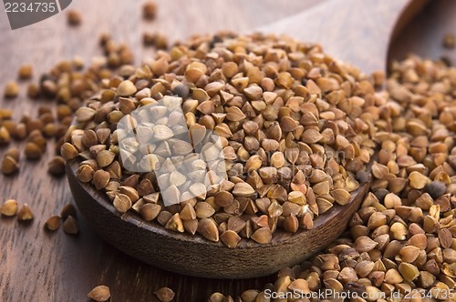 Image of Buckwheat seeds on wooden spoon in closeup 