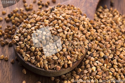 Image of Buckwheat seeds on wooden spoon in closeup 