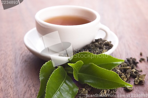 Image of cup of green tea with freh leaves