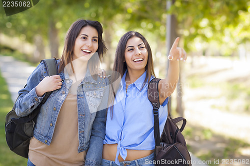 Image of Mixed Race Twin Sisters Wearing Backpacks and Pointing Outside