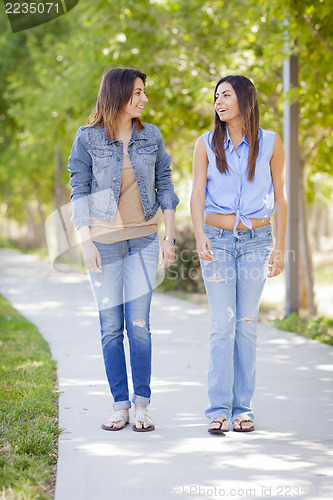 Image of Young Adult Mixed Race Twin Sisters Walking Together