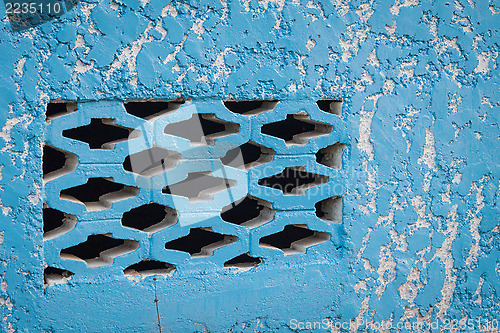 Image of Blue aged street wall with black brick holes