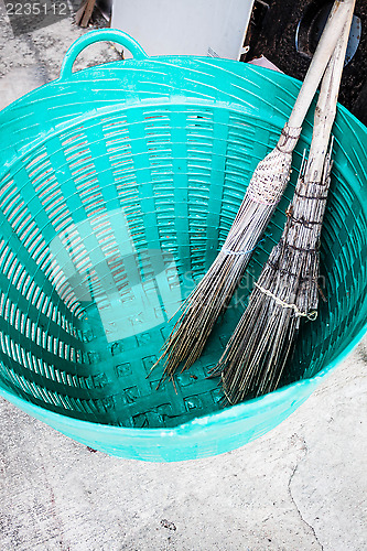 Image of Old brooms after sweeping keep in plastic basket 