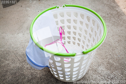 Image of Empty white plastic laundry basket on the floor