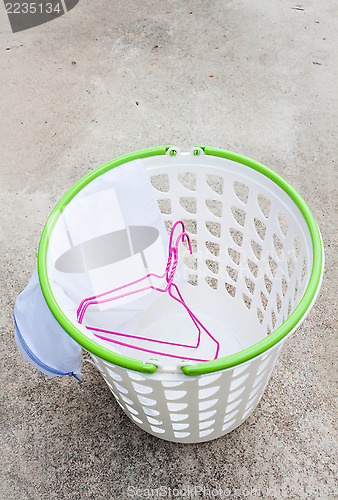 Image of Cloth hanger and wash bag in plastic laundry basket  