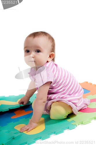 Image of Little cute baby sitting on the floor