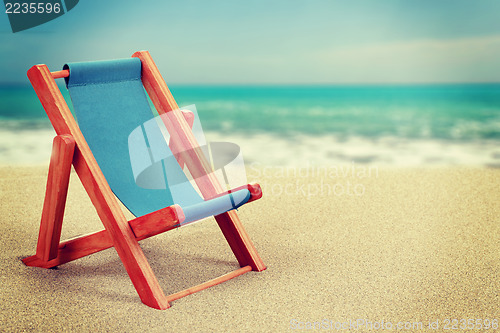 Image of Sun lounger in sandy beach vintage toned