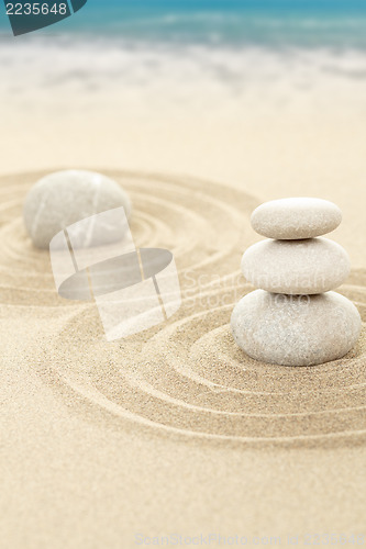 Image of Balance zen stones in sand with sea in background