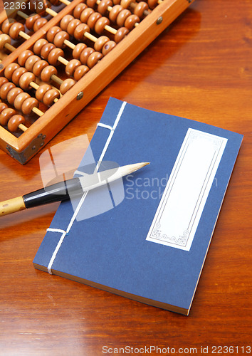 Image of Chinese book , abacus and writing brush