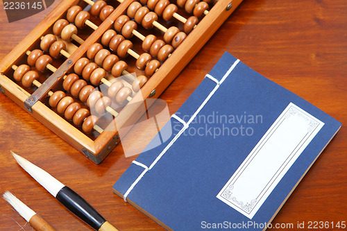 Image of Chinese book , abacus and writing brush