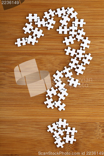 Image of Question mark made by puzzle on wood background 