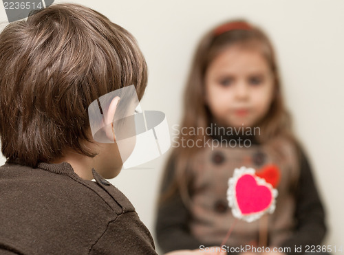 Image of Boy gives heart to little girl