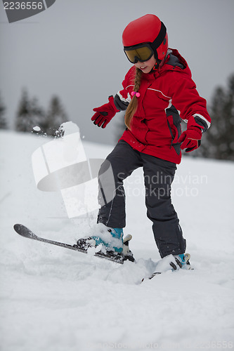 Image of Young girl skier tosses up  snow