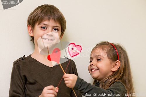 Image of Little girl and boy with red hearts