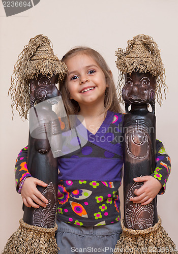 Image of Little girl with two ethnic dolls