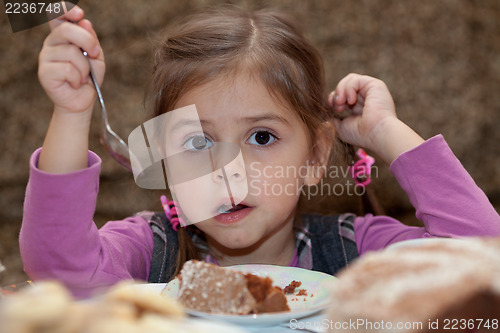 Image of Look of little girl eating cake