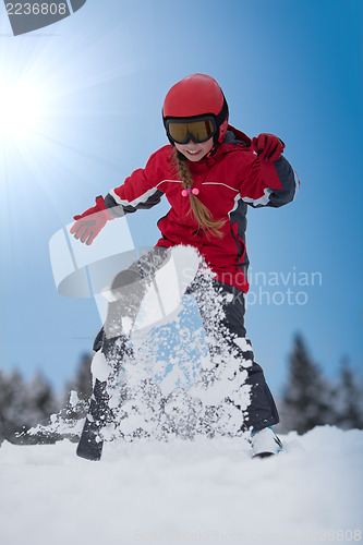Image of Young girl skier plays with snow