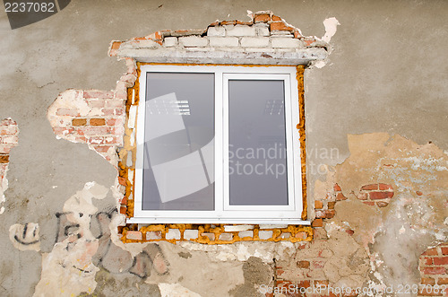 Image of renovation plastic window old brick house wall 