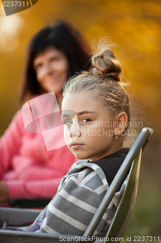 Image of Pretty young girl and mom in background