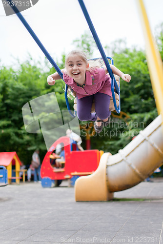 Image of Girl swinging and laughing