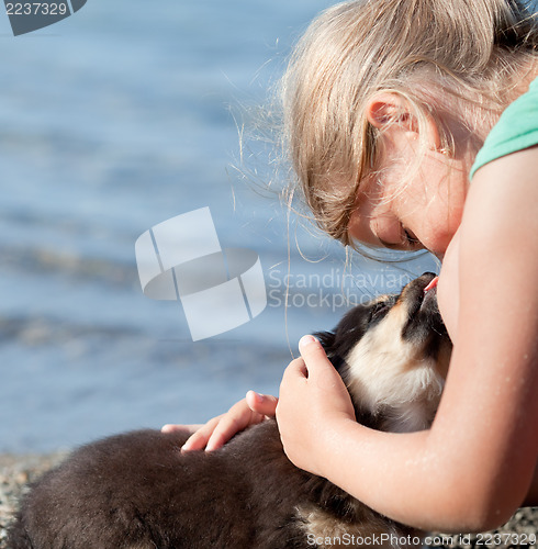 Image of Puppy licks child's nose