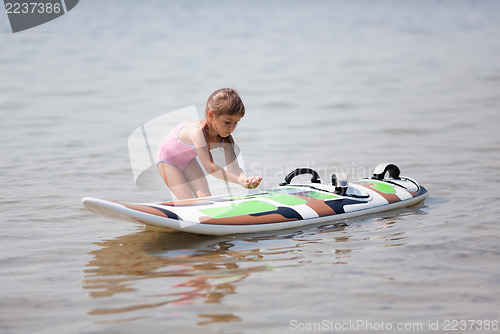 Image of Little girl and windsurfing board