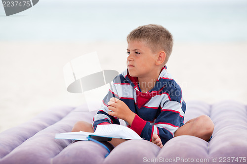 Image of Beautiful child reading on the beach