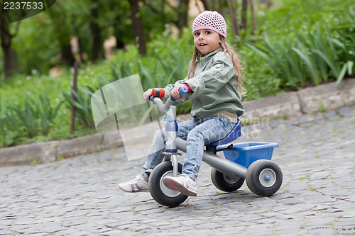 Image of Little girl ( 4-5) on tricycle