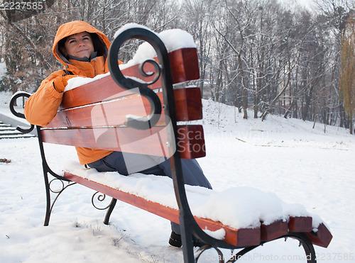 Image of Woman on snowy bench