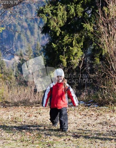 Image of Little girl walking in autumn forest