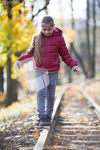 Image of Girl walking down train tracks