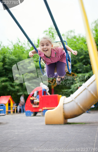 Image of Girl swinging and laughing