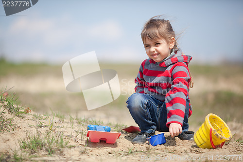 Image of Little girl playing with sand