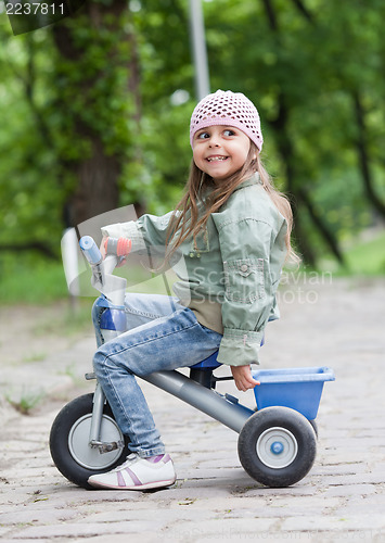 Image of Little girl ( 4-5) on tricycle