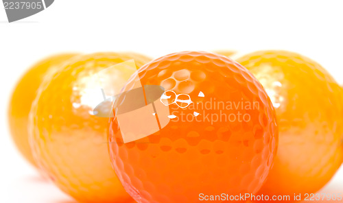 Image of Orange and golden golf balls