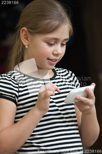 Image of Little girl typing sms on a smartphone