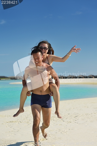 Image of happy young  couple enjoying summer on beach