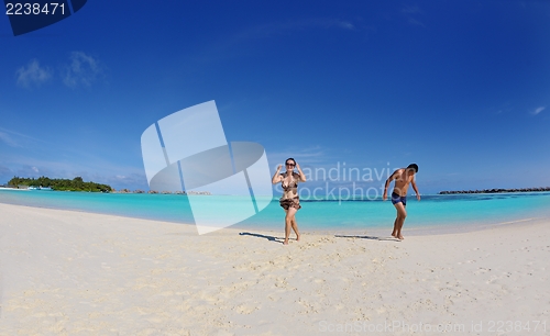 Image of happy young  couple enjoying summer on beach