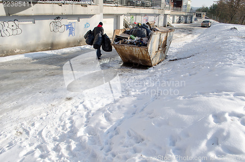 Image of man carries four bags garbage house container 